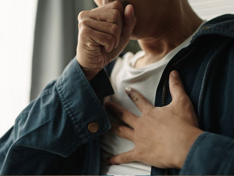 Man holding chest and coughing