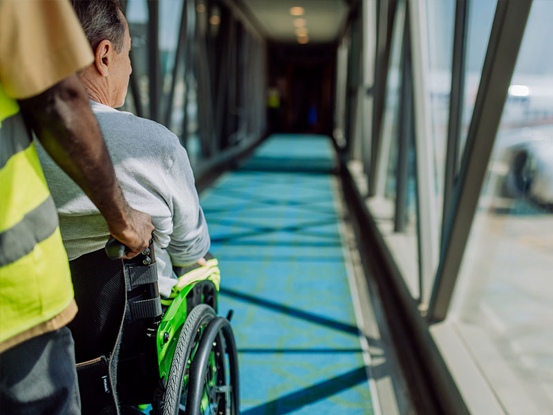 Man in wheelchair being pushed down gangway