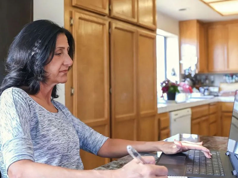 Woman on laptop in kitchen