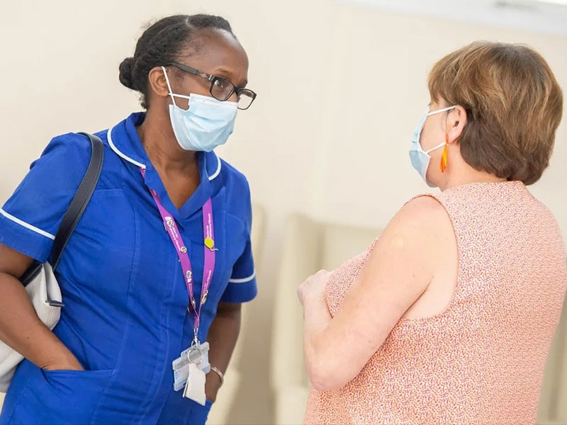 Nurse and patient talking wearing face masks