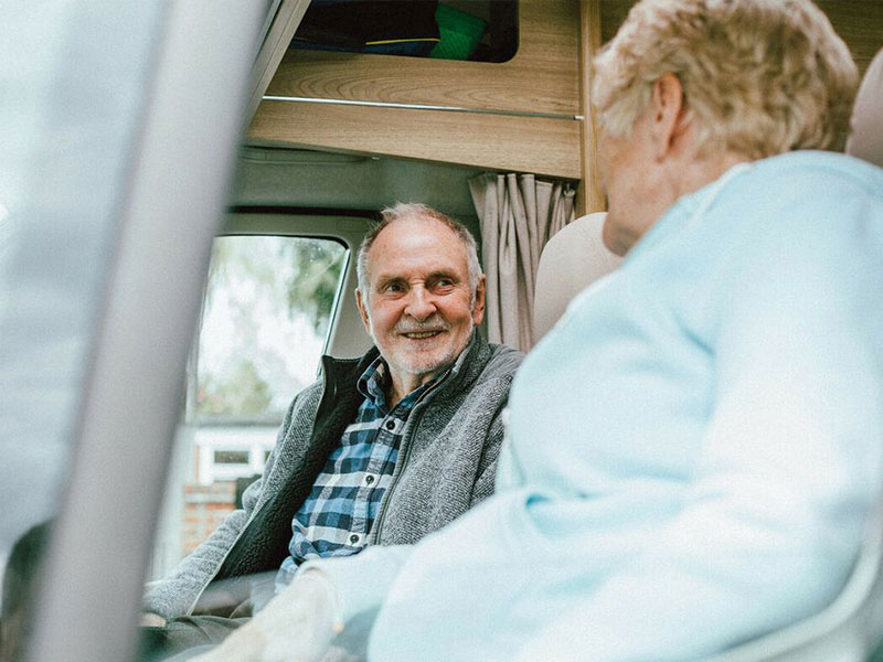 Woman and man chatting in front of campervan
